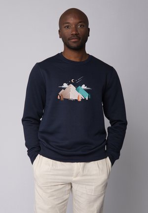 Donkere blauw sweatshirt met een grafisch ontwerp van bergen met bomen en een maan. Katoenen stof met een ronde hals en ribgebreide manchetten.