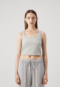 Top court gris à col carré, fabriqué en tissu en coton doux. Associé à un pantalon léger à rayures avec cordon de serrage.