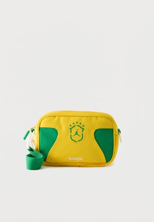 Sárga és zöld téglalap alakú oldaltáska "Brasil" felirattal és pajzs logóval, amelyen egy kosárlabdázó sziluettje és öt csillag látható.