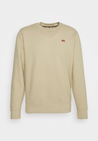 Felpa beige in misto cotone, con maniche lunghe, colletto rotondo e patch logo rosso sul lato sinistro del petto. Texture morbida con polsini a coste.