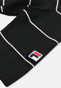 Sorte sokker med hvide striber og et lille broderet kvadratisk logo i rød, hvid og blå nær manchet.