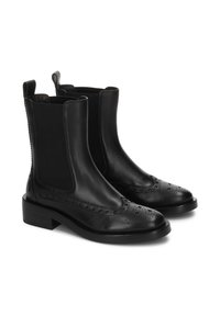 Botas de cuero negro hasta el tobillo con paneles laterales elásticos, detalles de brogue en la punta y una suela plana gruesa. Textura suave con un brillo mínimo.