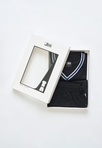 Sættet med sorte bomulds-pyjamas i en hvid æske, der indeholder en kortærmet top med v-udskæring og blå striber samt matchende shorts med elastisk talje.