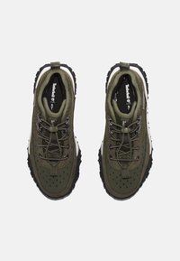 Olivgrön utomhusskor med strukturerad tyg, runda snören, förstärkt tå, svart gummisula och vadderad krage för stöd.