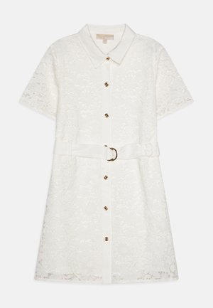 Fehér csipkebetétes ingruha rövid ujjakkal, gombos elülső résszel és egy kör alakú aranycsattal ellátott, illeszkedő övvel. Virágos mintázat részletei hangsúlyosak.