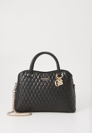Czarna pikowana skórzana torebka Guess z złotym łańcuszkowym paskiem, górnymi uchwytami oraz złotymi zawieszkami z logo na neutralnym tle.