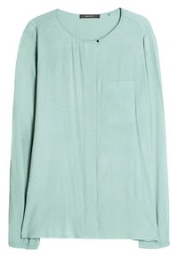 Helle türkisfarbene Bluse mit langen Ärmeln aus weichem Stoff. Sie hat einen runden Ausschnitt, eine Brusttasche und dezente Nähte an der Mittelnaht.