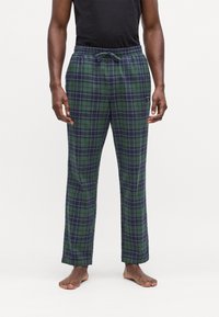 Groene en marineblauwe geruite flanellen pyjamabroek met een elastische tailleband en een trekkoord, in een losse pasvorm. Zachte textuur, lang ontwerp.