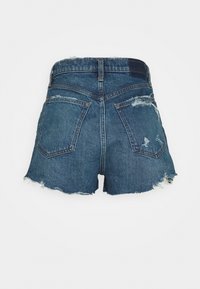 Shorts en denim avec un ourlet effiloché, des détails déchirés et deux poches arrière. Couleur : bleu moyen. Design : taille haute, coupe décontractée.