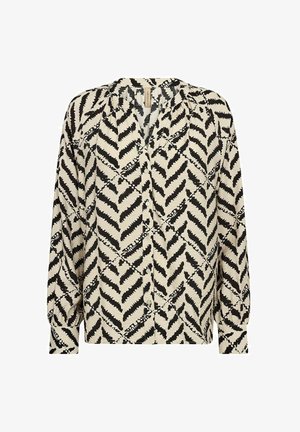 Button-up blouse in cream with black zigzag pattern. Features long sleeves, pleated shoulders, and a relaxed fit design.