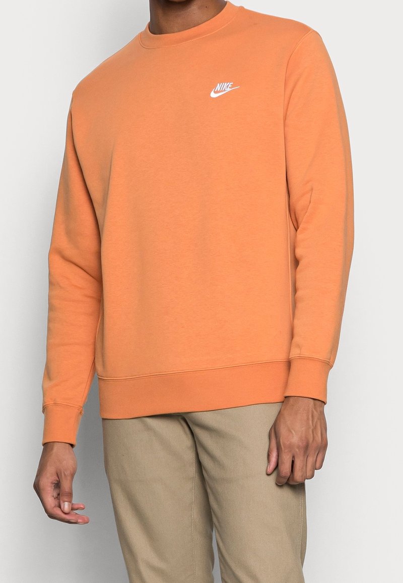 Sudadera naranja de mezcla de algodón, con cuello redondo y puños de canalé; logo de Nike en blanco en el lado izquierdo del pecho.