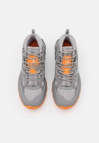 Chaussures de randonnée grises avec un tissu en mesh texturé, des accents argentés, des touches orange et une semelle robuste. Comprend des lacets renforcés et une languette de traction.