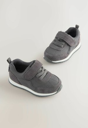 Hallhalli kangast ja nokitallaga spordijalatsid, millel on takjakinnitus ja elastsed nöörid. Valged vaheplokid tekstuuriga kummitaldadega. Ümar varvastega disain.