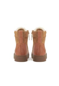 Stivali alla caviglia in suede marrone con tacco in pelle liscia, interno in shearling e zip posteriori; suola in gomma testurizzata per aderenza.