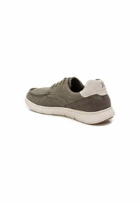Zapato de tela verde oliva con acentos marrón oscuro, puntera redondeada, suela plana y área del talón trasero de ante. Presenta detalles de cordones y costuras.