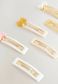 Spinki do włosów w pastelowych odcieniach różu, bieli i złota; z akcentami kokardy oraz błyszczącym metalicznym wykończeniem na płaskiej podstawie z centralnym uchwytem.