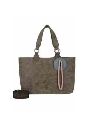 Brown suede tote bag with double handles, round blue tag, pink wrist strap, and separate brown adjustable shoulder strap.