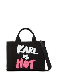 Sac fourre-tout noir en toile avec double poignée et bandoulière amovible. Présente un texte en gras "KARL est CHAUD" en lettres blanches et roses ressemblant à de la peinture.