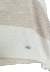 Leichtes Strickoberteil mit abwechselnd beigen und weißen Streifen. Verfügt über ein silbernes Logoschild mit "Key Largo" auf einer runden Metallplatte.