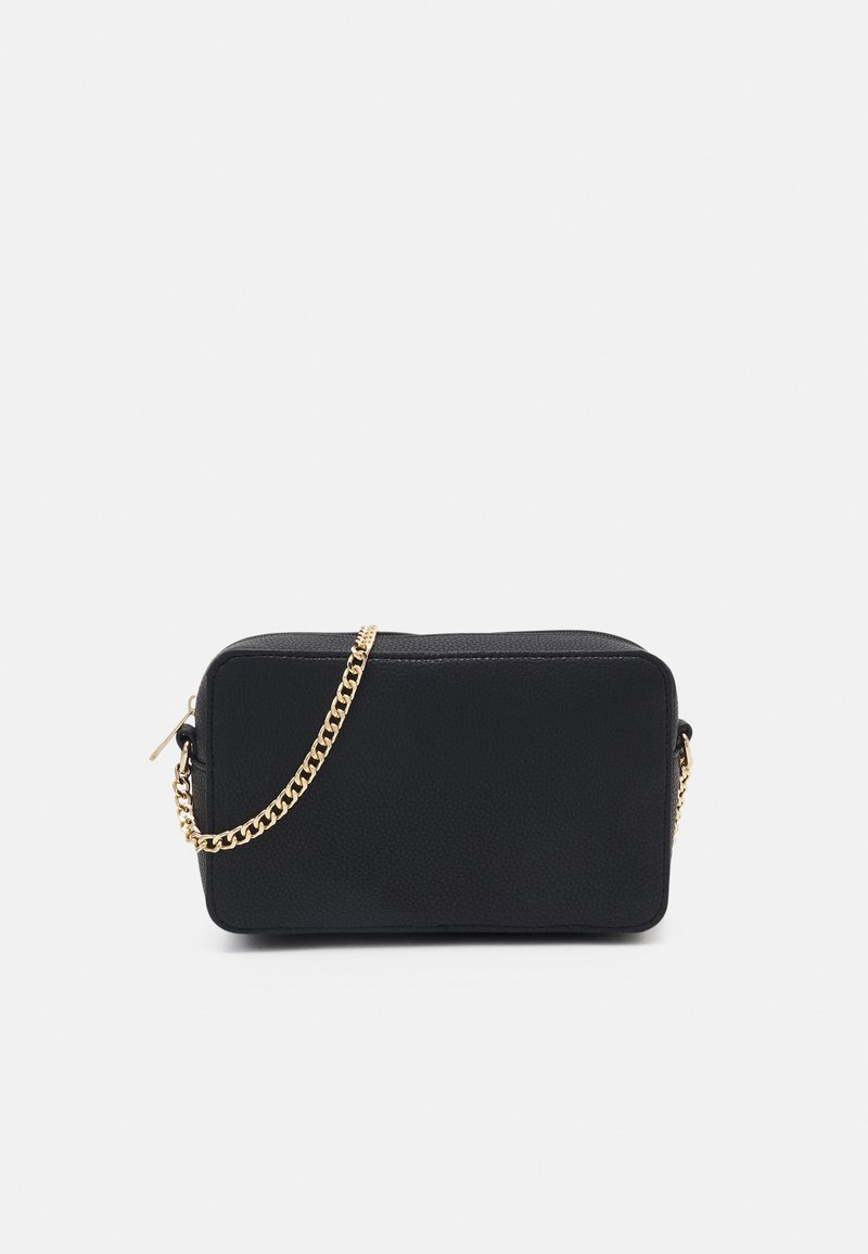 Sac en bandoulière noir en cuir texturé rectangulaire avec chaîne dorée et fermeture éclair sur fond blanc.