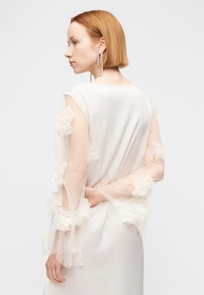 Φόρεμα με μακριά μανίκια από λευκό σατέν, με floral εφαρμογές σε διάφανα τούλινα μανίκια. Λείο ύφασμα, άνετη γραμμή, λαιμόκοψη σε σχήμα scoope στο πίσω μέρος.