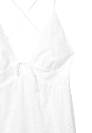 Robe blanche brodée avec un décolleté en V profond, des motifs floraux, un lien à la taille et des bretelles croisées dans le dos.