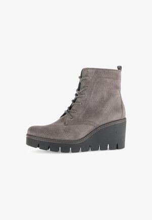 Bottines grises en daim avec une semelle compensée, présentant un laçage, un bout rond et une semelle extérieure en caoutchouc noir texturé pour une meilleure adhérence.