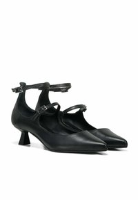 Scarpe col tacco alto in pelle nera con punte appuntite, dotate di cinturini alla caviglia e tacco quadrato piccolo. Texture liscia, design minimalista.