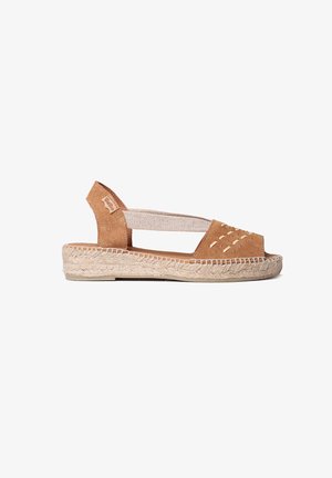 Tan suede espadrille sandal with cut-out details, elastic side straps, and a woven jute sole. Open-toe design for breathability.