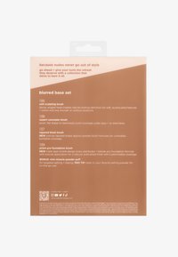 Dos du paquet d'un ensemble de pinceaux de maquillage listant quatre types de pinceaux et un mini-tampon de poudre bonus avec des conseils d'utilisation et les labels sans cruauté et végan.