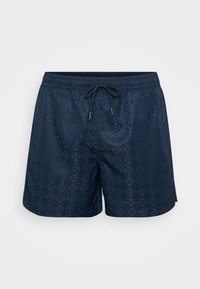 Mørkeblå badebukser med et tonalt geometrisk mønster, elastisk talje med snøre og en afslappet pasform. Glat tekstur.