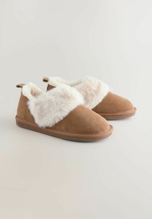 Braune Wildlederhausschuhe mit dickem cremefarbenem Kunstfellrand und Gummisohlen, entworfen für behaglichen Komfort und Wärme drinnen.