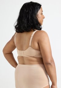 Beige bh med justerbara band, hak-och-ögonstängning bak, ribbad textur och spetser detaljer. Matchas med matchande beige högmidjade trosor.
