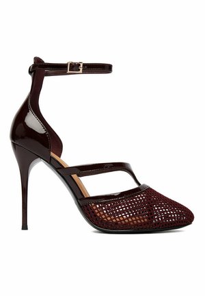Décolleté con tacco a stiletto color borgogna scuro, cinturino alla caviglia, corpo in pelle verniciata lucida e punta appuntita con design a rete intrecciata.