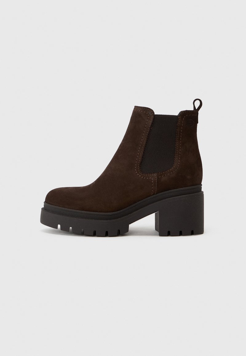 Bottines en suède marron avec des panneaux élastiques sur les côtés et une languette, dotées d'un talon bloc et d'une semelle crantée pour l'adhérence.