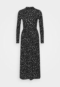 Svart långärmad klänning med ett stjärnmönster i vitt, med en figursydd midja och utsvängd kjol, tillverkad av mjukt tyg.