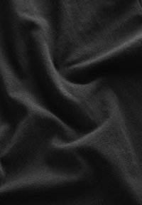 Tessuto di cotone nero con una texture liscia, caratterizzato da pieghe e grinze sottili che creano un senso di profondità e dimensione.