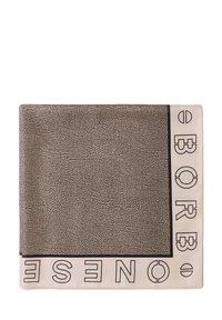 Écharpe en tissu carrée avec un motif texturé noir et crème, ornée de texte en caractères gras sur les bords et d'une finition lisse.