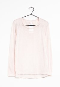 Light pink long-sleeve shirt made of soft fabric, featuring a round neckline and a slightly sheer panel on the shoulders. Hangs from a black hook.