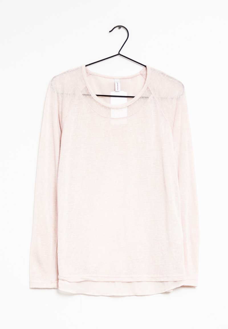 Light pink long-sleeve shirt made of soft fabric, featuring a round neckline and a slightly sheer panel on the shoulders. Hangs from a black hook.