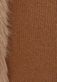 Tessuto marrone a coste lavorato a maglia con un bordo in morbida pelliccia sintetica marrone chiaro. La texture è calda e soffice, che valorizza il design complessivo.