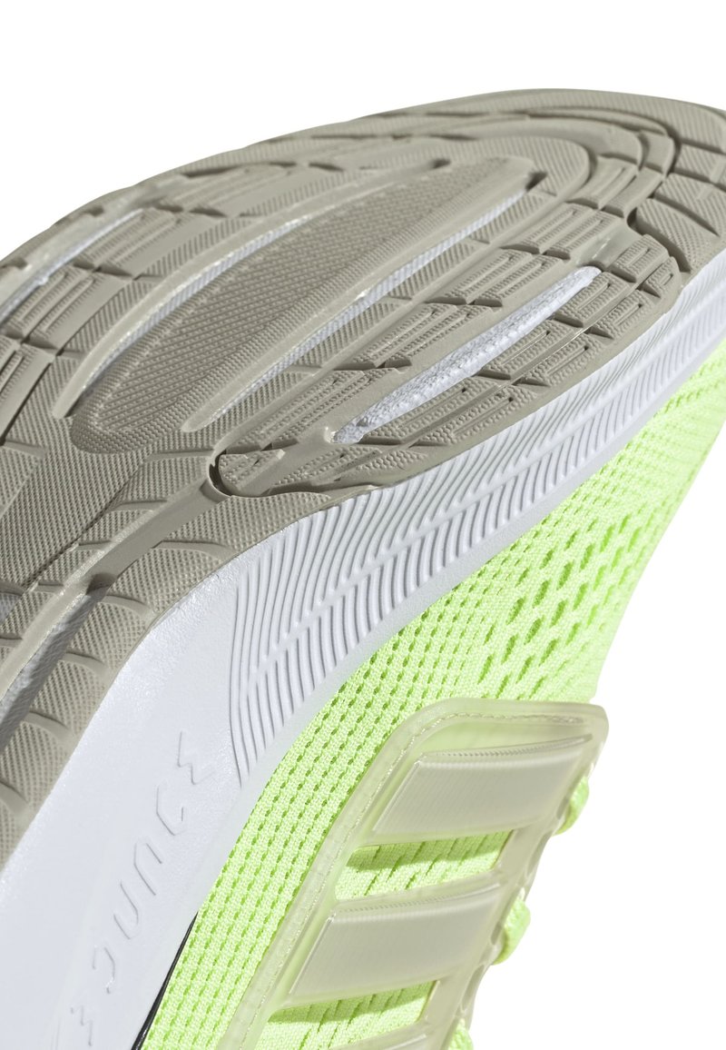 Zapatilla de correr ligera con una parte superior de malla en un brillante color verde neón, una suela de goma texturizada en color beige y acentos blancos a lo largo de la entresuela.