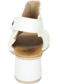 Sandale à talons blancs avec une tige texturée, un dos ouvert et une sangle ajustable. Dispose d'une semelle intérieure lisse couleur tan et d'un talon chunky blanc.