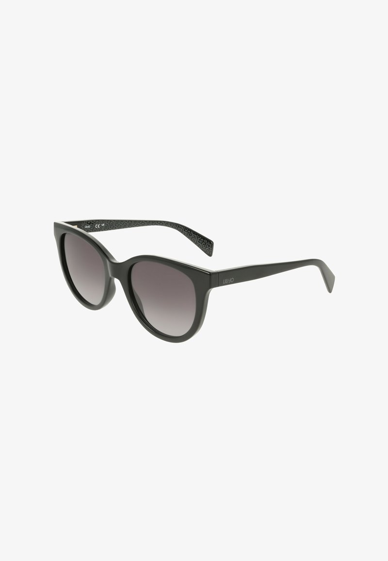 Lunettes de soleil œil de chat noires avec des verres dégradés foncés et une monture lisse et brillante, présentées en vue de trois quarts sur fond blanc.