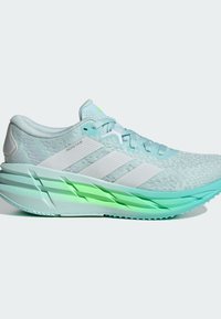 Lichtblauwe hardloopschoenen met een gestructureerde bovenkant, witte strepen en een groene vergrendelingszool. Heeft een gevoerde hiel en een vetersluiting.
