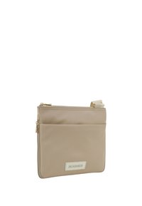 Beige nylon crossbody taske med en glat tekstur, der har en frontlomme med lynlås og et logo patch. Hardware i guldtoner.