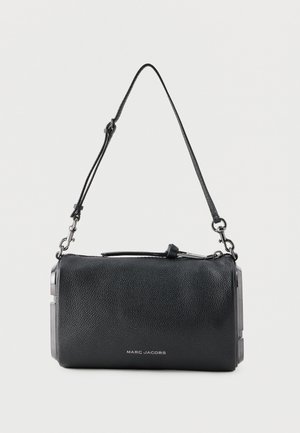 Schwarze Marc Jacobs Lederschultertasche mit verstellbarem Riemen und silberfarbenen Beschlägen vor einfarbigem Hintergrund.