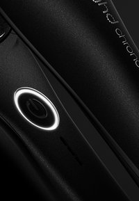 Fer à lisser noir avec une finition mate lisse, comportant un bouton d'alimentation circulaire avec un anneau lumineux et des éléments de design élégants.