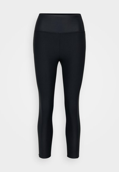 Sorte leggings med teksturert overflate, høy midje og glatte sider. Laget av stretchy materiale egnet for trening.