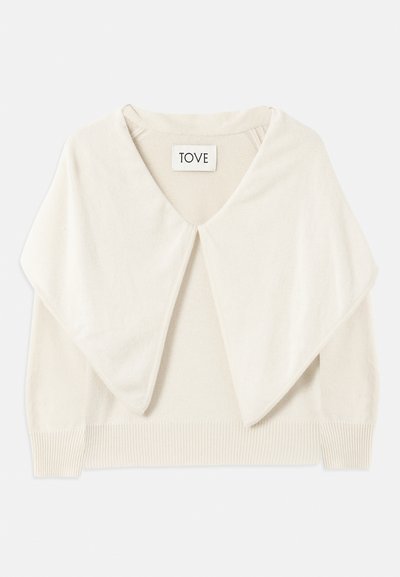 Kremni pulover iz pletenine z širokim ovratnikom, dolgimi rokavi in rebrastim robom. Mehak tekstura in minimalističen dizajn. Oznaka pravi "TOVE."